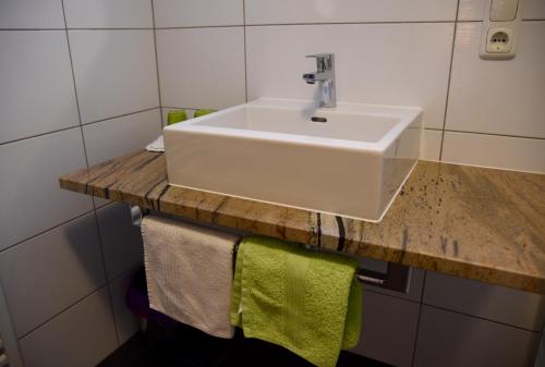 a bathroom with a sink and towels on a counter at Frühstückspension Pachler in Gosau
