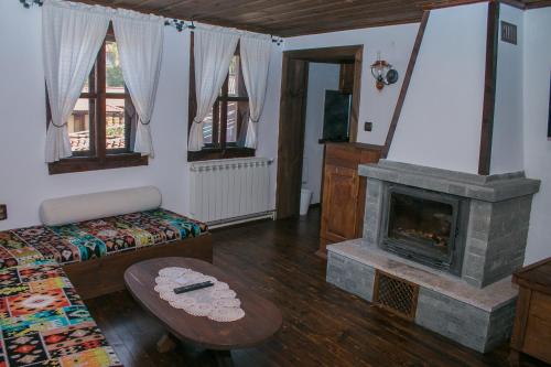 a living room with a fireplace and a couch at ЧОЛАКОВАТА КЪЩА in Koprivshtitsa