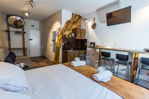 a bedroom with a large bed and a kitchen at GraffitiSuites#Bronze in Thessaloniki