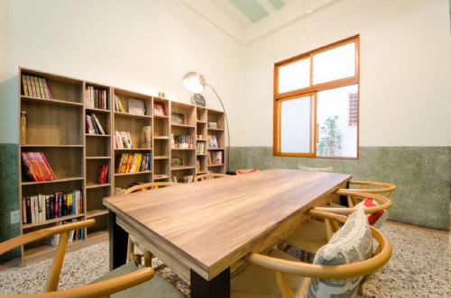 a large room with a wooden table and bookshelves at Freedom B&B in Tainan
