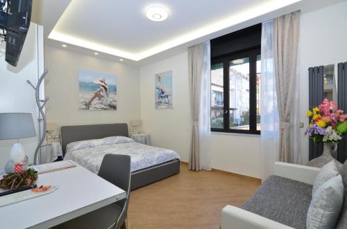 a bedroom with a bed and a desk and a table at Caserta Deluxe in Caserta