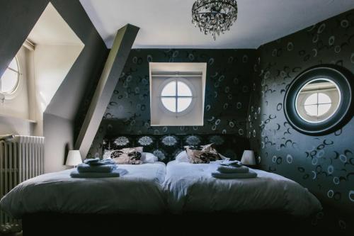 two beds in a bedroom with green walls and windows at Kasteel Pietersheim Maastricht - Lanaken in Lanaken