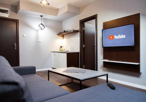 a living room with a couch and a flat screen tv at Apartmani Zrenjanin in Zrenjanin