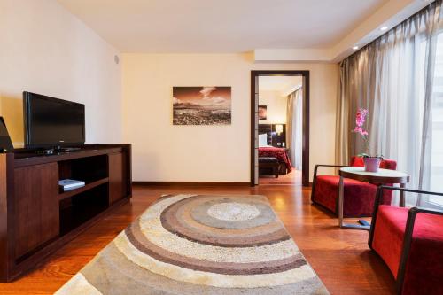 a living room with a couch and a television and a living room at Exe Budapest Center in Budapest