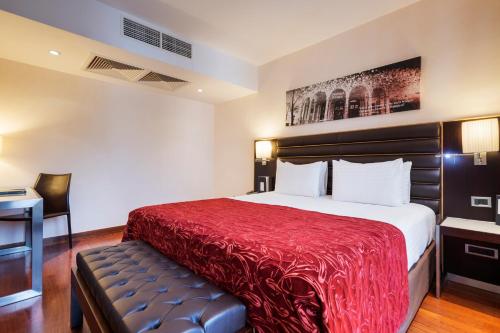 a hotel room with a bed with a red blanket at Exe Budapest Center in Budapest