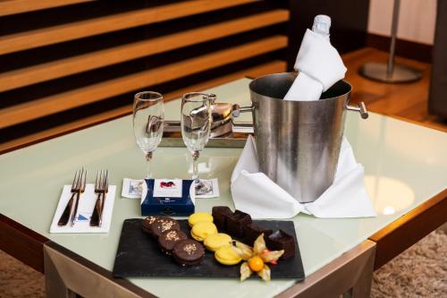 a table with a plate of chocolate and wine glasses at Exe Budapest Center in Budapest