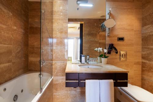 uma casa de banho com uma banheira e um lavatório em Exe Budapest Center em Budapeste
