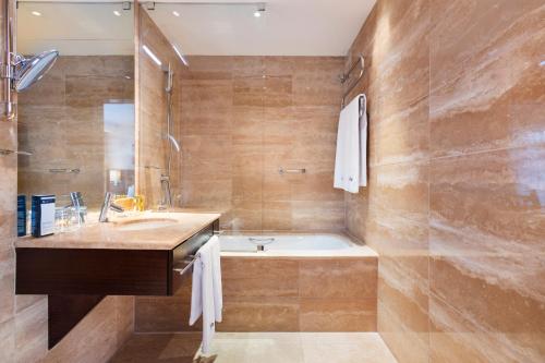 a bathroom with a tub and a sink at Exe Budapest Center in Budapest