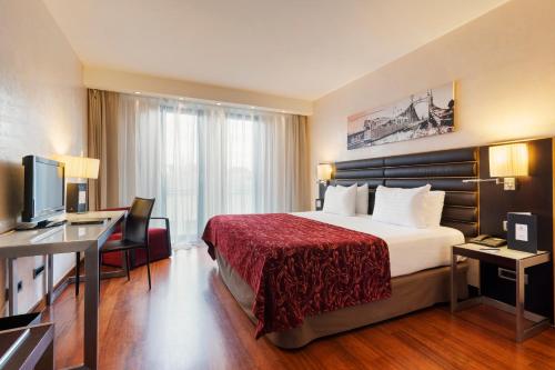 a hotel room with a bed and a desk at Exe Budapest Center in Budapest