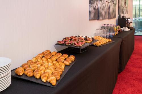 a table with several trays of bread and pastries at Exe Budapest Center in Budapest