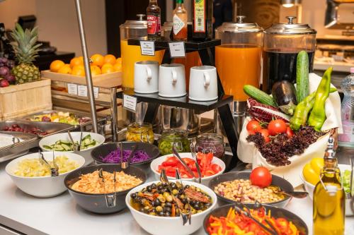 a buffet with many bowls of food on a counter at Exe Budapest Center in Budapest