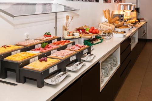 a buffet line with many different types of food at Exe Budapest Center in Budapest