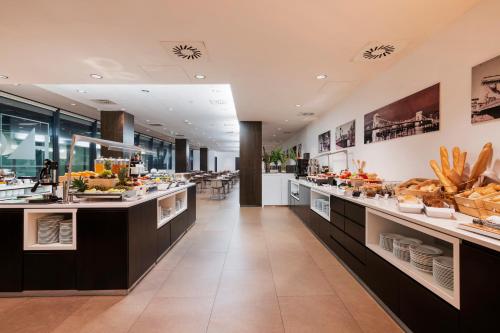 a cafeteria with a buffet line with food on display at Exe Budapest Center in Budapest
