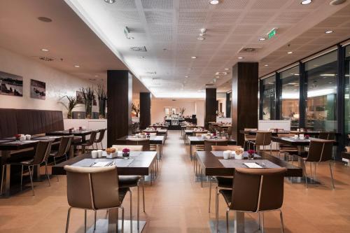 a dining room with tables and chairs and windows at Exe Budapest Center in Budapest