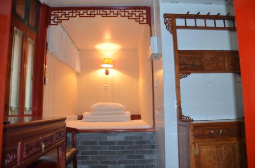 a small room with a bunk bed and a mirror at Qianmen Courtyard Hotel in Beijing