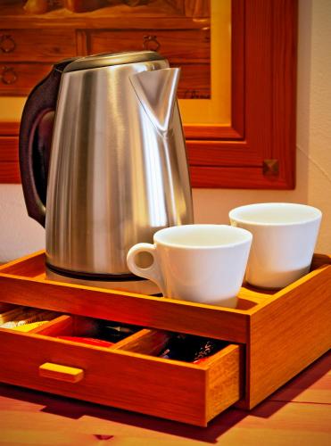 a tea kettle and cups on a wooden tray at Kempinski Hotel Grand Arena Bansko in Bansko