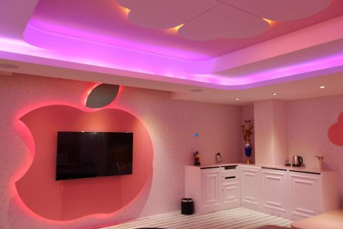 an apple on the wall of a kitchen with a tv at Yosemite Motel - Taiyuan Branch in Taichung