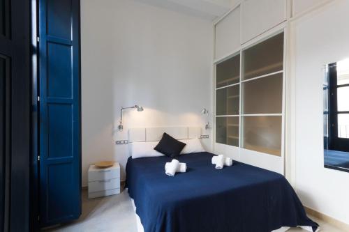 Un dormitorio con una cama azul con dos toallas encima. en Valentia Apartments - Mercado Central, en Valencia