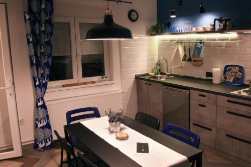 HILLS Apartments في فرساك: مطبخ مع طاولة مع كراسي ومغسلة