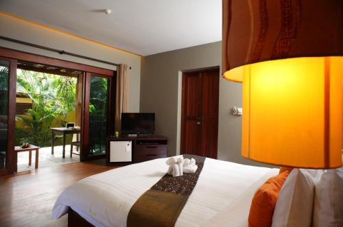 a bedroom with a bed with two teddy bears on it at Chongfah Resort Khao Lak - SHA Extra Plus in Khao Lak