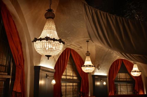 a room with two chandeliers and red curtains at The Bedford Balham - Live Music Venue in London