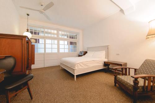 北港鎮的住宿－暗街宅內民宿，卧室配有床、椅子和窗户。