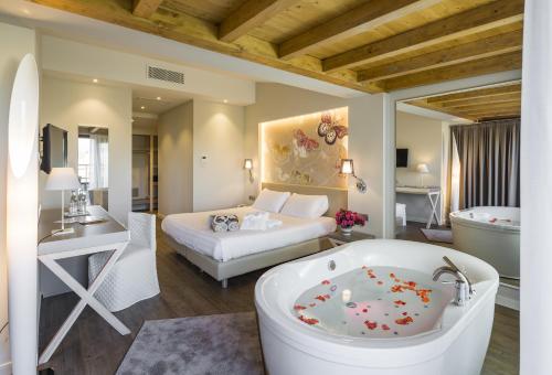 1 dormitorio con 1 cama y baño con bañera. en Hotel Resort & Spa Miramonti en Rota d'Imagna
