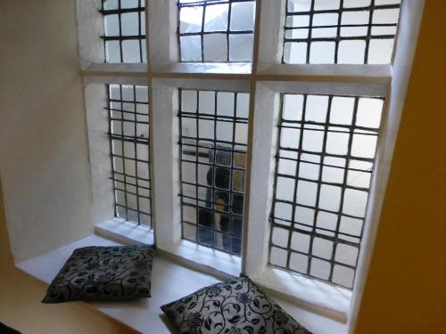 a room with three windows and two pillows at Witherslack Hall Farmhouse in Grange Over Sands