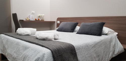 a bedroom with two beds with white sheets and blue pillows at Tre Stelle al Duomo in Catania