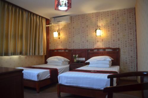 a hotel room with two beds and a window at Qianmen Courtyard Hotel in Beijing