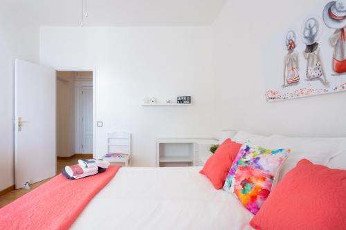 a bedroom with a white bed with red pillows at Frontline Beach Apartment in San Andrés