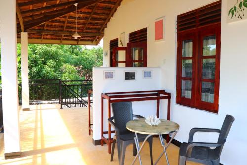 a kitchen and dining room with a table and chairs at Relax Beach House in Tangalle