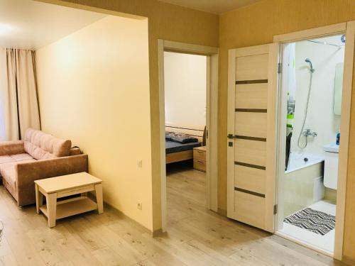 トムスクにあるNovye apartamenty na Matrosova 3の小さなリビングルーム(ソファ付)、バスルームが備わります。