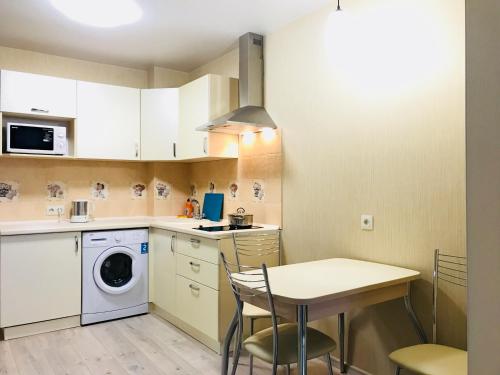 トムスクにあるNovye apartamenty na Matrosova 3の小さなキッチン(テーブル、洗濯機付)