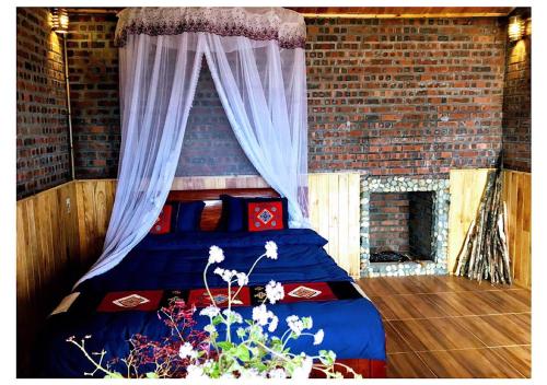 - une chambre avec un lit dans un mur en briques dans l'établissement Sapa Hmong Bungalow Homestay, à Sa Pa