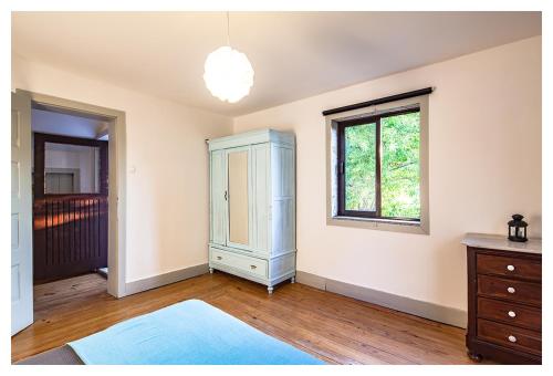 um quarto com um armário azul e uma janela em Quinta da Regadas em Arouca