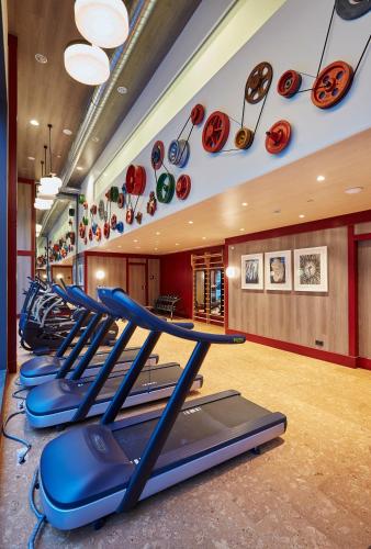 a gym with a row of treadmills and plates on the wall at Radisson Blu 1882 Hotel, Barcelona Sagrada Familia in Barcelona