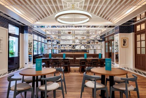 a restaurant with tables and chairs and a bar at Radisson Blu 1882 Hotel, Barcelona Sagrada Familia in Barcelona