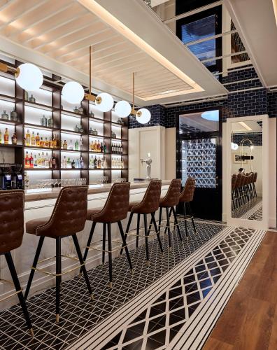 a bar with chairs and a table in a restaurant at Radisson Blu 1882 Hotel, Barcelona Sagrada Familia in Barcelona