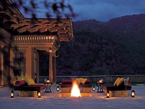 a fire pit with couches and tables in front of a building at Pemako in Thimphu