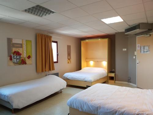 a hotel room with two beds and a window at Hotel Le Saint Vincent Lyon Sud in Vourles