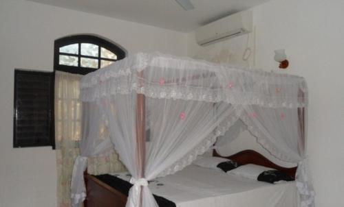 a bed with a canopy in a room with a window at Sunset Beach Residence in Panadura
