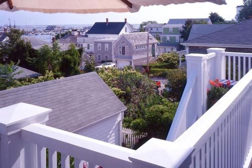 a white balcony with a white fence and houses at Benchmark Inn in Provincetown