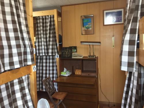 a room with a desk with a computer and a window at Guest house daisho oshiro asobi in Matsue
