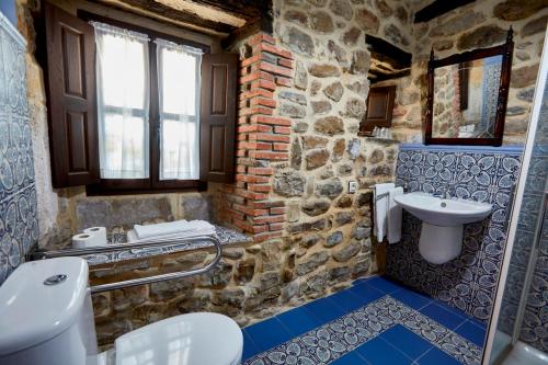 a stone bathroom with a sink and a toilet at Posada Rural Ochohermanas in Las Fraguas