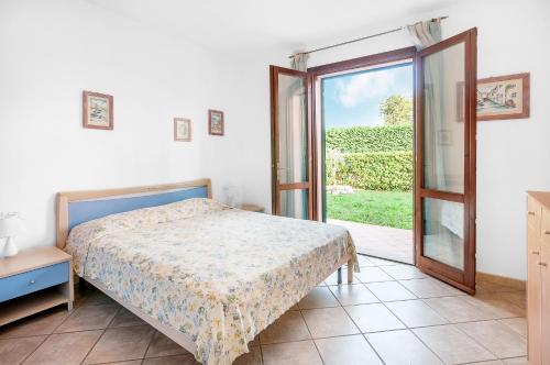 a bedroom with a bed and a sliding glass door at Golfo 4 in Marina di Campo