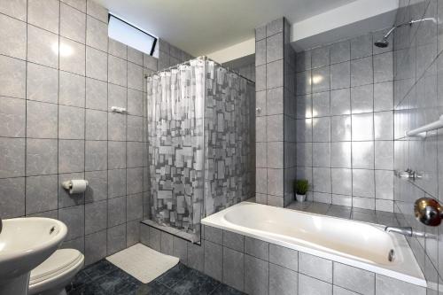 a bathroom with a tub and a toilet and a sink at Hotel Residencial Los Frayles in Paracas