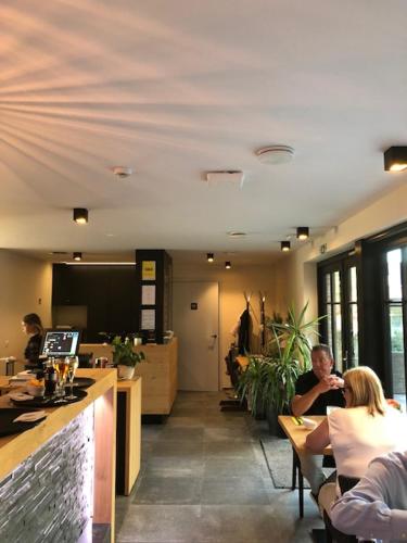 un grupo de personas sentadas en mesas en un restaurante en B&B Sasput, en Hasselt