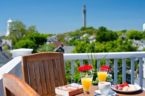 a table with a plate of food and two glasses of orange juice at Benchmark Inn in Provincetown