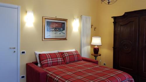 una camera con un letto con una coperta rossa a scacchi di Casa Max a Napoli